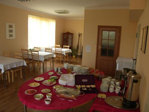 a table with a red table cloth with food on it at Noclegi Apro in Gdańsk