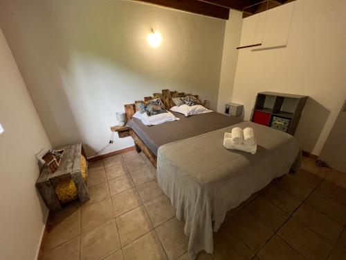 a bedroom with a bed with two white shoes on it at Villa au calme avec Jacuzzi, Villa Le Boursoie in Les Abymes