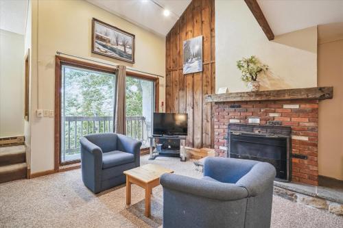 a living room with two chairs and a fireplace at Whiffletree E8 3-Bedroom Condo with Ski Access, Shuttle, and Fireplace in Killington