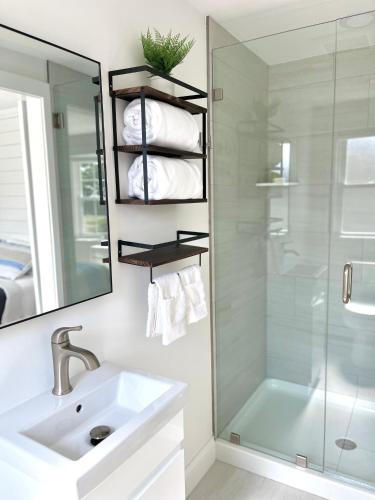 a bathroom with a sink and a shower and a mirror at Kingfisher Harwich Port in Harwich Port