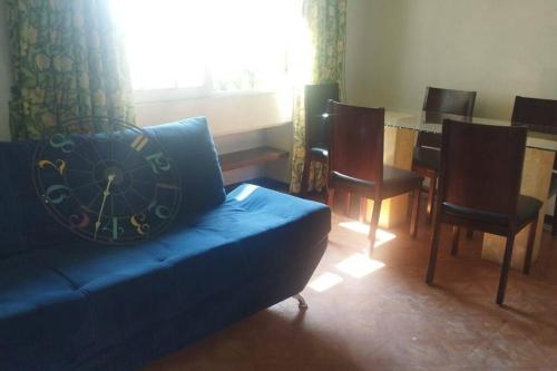 una sala de estar con un sofá azul con un reloj. en DEPARTAMENTO CERCA DE PERINORTE, en Tultitlán