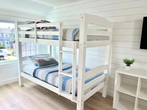 two bunk beds in a room with a desk at Kingfisher Harwich Port in Harwich Port