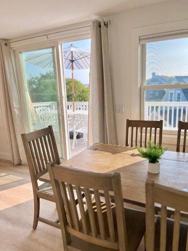a dining room with a table and chairs with a view of the ocean at Kingfisher Harwich Port in Harwich Port