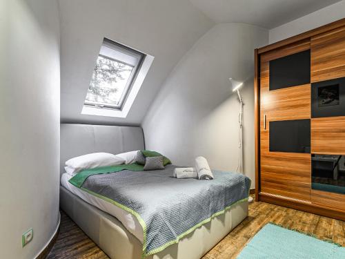 a small bedroom with a bed and a window at VisitZakopane - White Valley Apartment in Zakopane