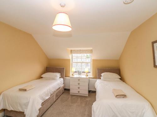 two beds in a room with a window at Wolds Way in Bainton