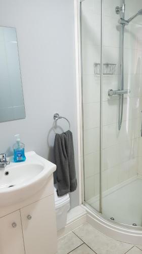 a white bathroom with a shower and a sink at Comfortable Family Home in Immingham in Immingham