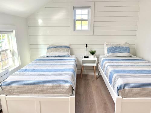 two beds in a room with white walls at Kingfisher Harwich Port in Harwich Port