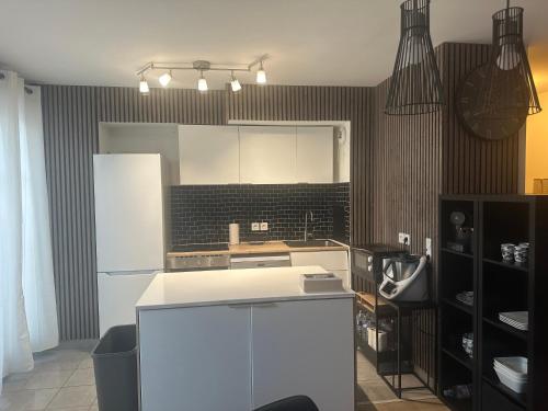 a kitchen with a white refrigerator and black tiles at PENTHOUSE Terrasse Jacuzzi 6 voyageurs in Le Blanc-Mesnil