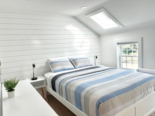 a white bedroom with a bed and a window at Kingfisher Harwich Port in Harwich Port