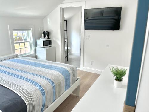 a bedroom with a bed and a flat screen tv at Kingfisher Harwich Port in Harwich Port