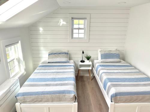 two beds in a room with white walls at Kingfisher Harwich Port in Harwich Port