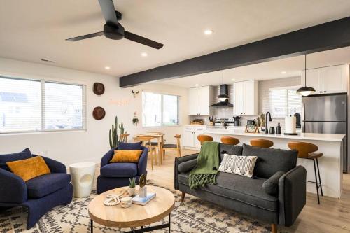 a living room with a couch and chairs and a kitchen at Wild West Disco Haus 2! New Hot Tub, Patio + Gym in Denver