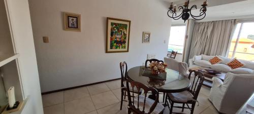 comedor y sala de estar con mesa y sillas en Depto Daria Punta del Este, en Punta del Este