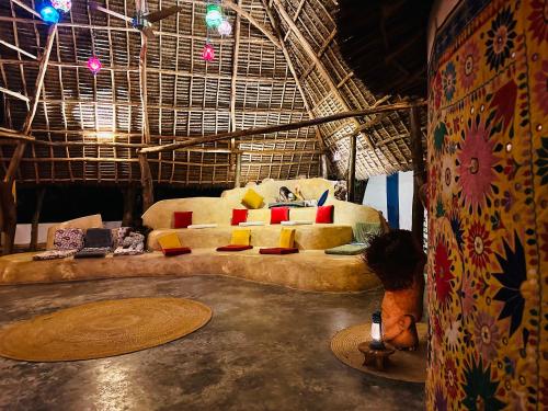 - un salon avec un grand canapé et des oreillers colorés dans l'établissement Kameleon Blue, à Kizimkazi