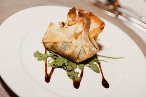a white plate with a piece of food on it at Bukela Game Lodge - Amakhala Game Reserve in Amakhala Game Reserve