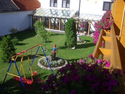 einen Garten mit Spielplatz und Schaukel in der Unterkunft Gästehaus und Weinbau Zur Wiederkehr Strudler in Podersdorf am See
