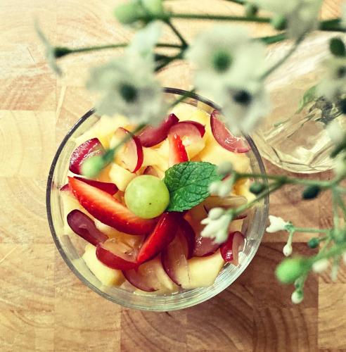 a glass bowl of fruit with grapes and apples at Léhontine in Dinan