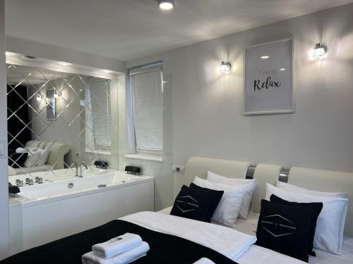 a bedroom with a tub and a bed and a sink at Apartamenty Modrzewiowa Zator in Piotrowice