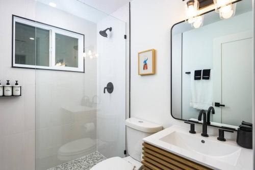a white bathroom with a sink and a mirror at Wild West Disco Haus! New Hot Tub, Patio + Gym in Denver
