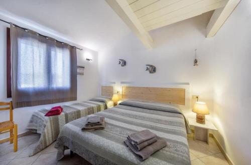 1 dormitorio con 2 camas y ventana en B&B Rotta Per Tavolara, en Porto San Paolo