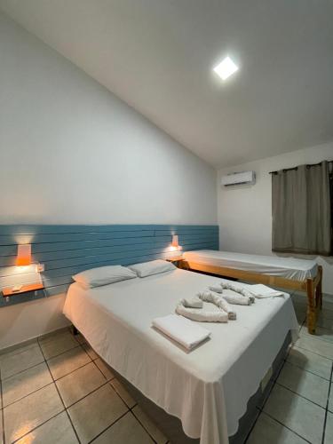 納塔爾的住宿－Pousada Encanto dos Mares，一间卧室配有两张带毛巾的床