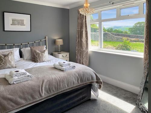 a bedroom with a bed with towels on it at Keepsake View in Two Dales