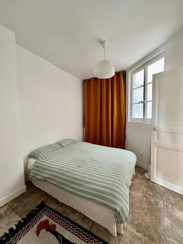 een slaapkamer met een bed in een kamer met een raam bij Appartement Montpellier centre in Montpellier