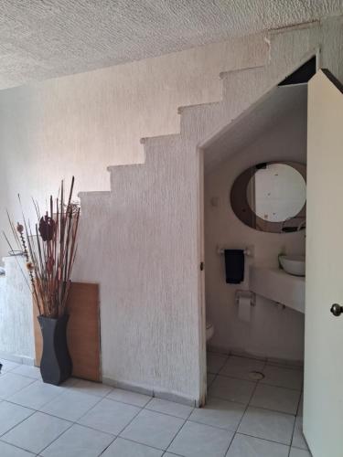 ein Badezimmer mit einer Treppe, einem WC und einer Vase in der Unterkunft Casa Laguna in Coyuca