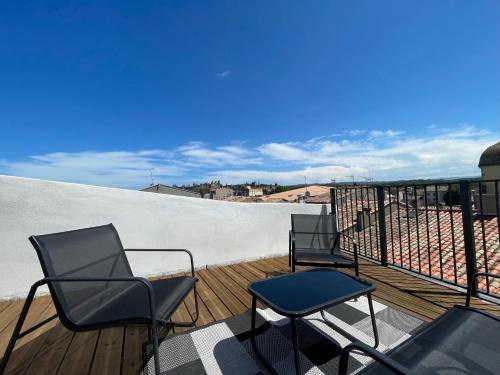 two chairs and a table on a balcony at Rooftop N°38 - Rooms et Studios - Vue Cité Médiévale in Carcassonne
