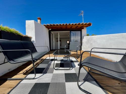 une terrasse avec des chaises et une table sur une maison dans l'établissement Rooftop N°38 - Rooms et Studios - Vue Cité Médiévale, à Carcassonne