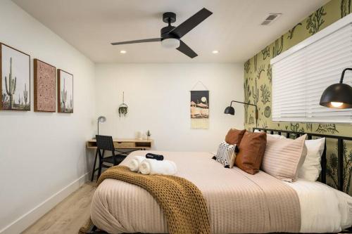 a bedroom with a bed with a ceiling fan at Wild West Disco Haus! Sleeps 12, Hot Tub + Gym! in Denver