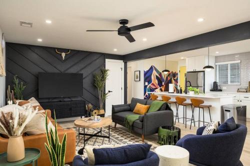 a living room with a couch and a kitchen at Wild West Disco Haus! Sleeps 12, Hot Tub + Gym! in Denver