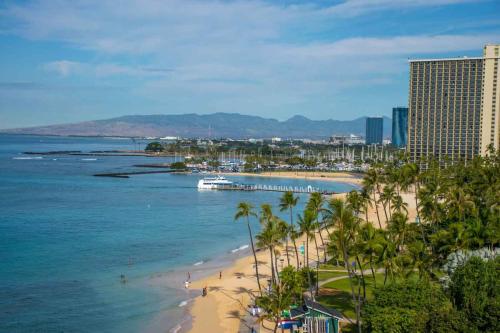 uma praia com palmeiras e um navio de cruzeiro na água em Waikiki Shore by OUTRIGGER - Select Your Unit em Honolulu