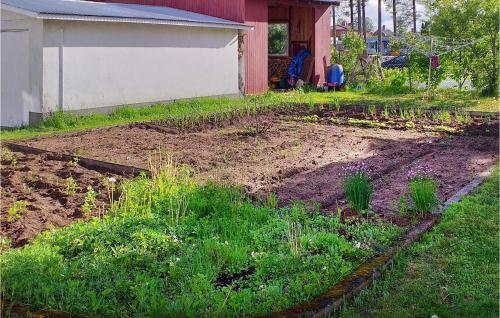 a garden with grass and weeds in front of a house at 2 Bedroom Nice Apartment In Hultsfred in Hultsfred