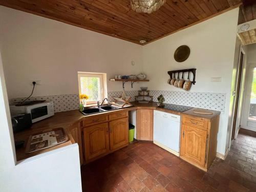 a kitchen with wooden cabinets and a counter top at Gîte à la campagne et son jacuzzi privatif 