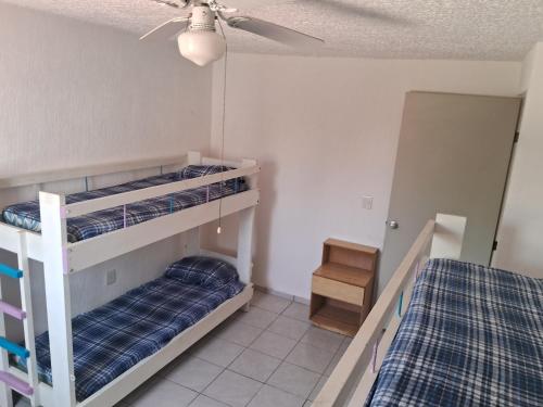 1 Schlafzimmer mit 2 Etagenbetten und einem Deckenventilator in der Unterkunft Casa Laguna in Coyuca
