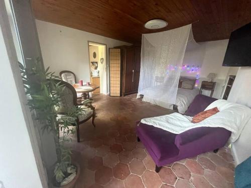 a bedroom with a bed and a table with a plant at Gîte à la campagne et son jacuzzi privatif 