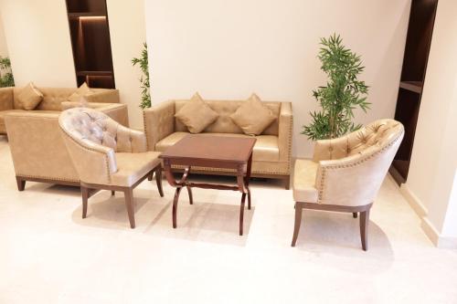 a living room with a couch and two chairs and a table at Dolphin Continental Hotel in Kuwait
