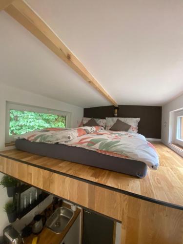a bedroom with a bed on a wooden shelf at Tiny house Malý gurmán 