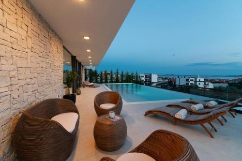 a living room with chairs and a swimming pool at Villa Aurum in Zadar