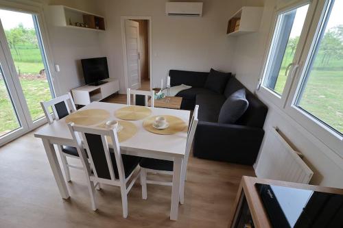 a living room with a table and a couch at Nový mobilheim (srubového typu) in Stropešín