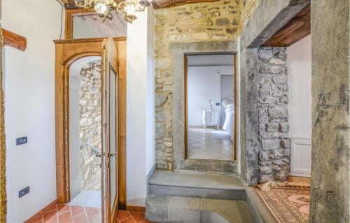pasillo con pared de piedra y espejo en 3 Bedroom Cozy Home In Comano, en Comano