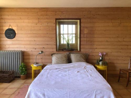 ein Schlafzimmer mit einem Bett in einer Holzwand in der Unterkunft Le Domaine de la Cloche in Saint Pavace