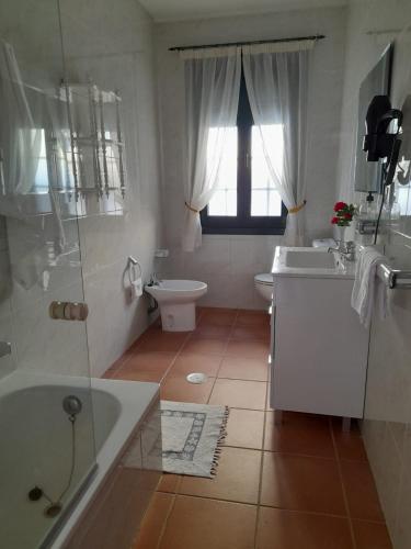 a bathroom with a tub and a toilet and a sink at Casa Concha in Porto do Son