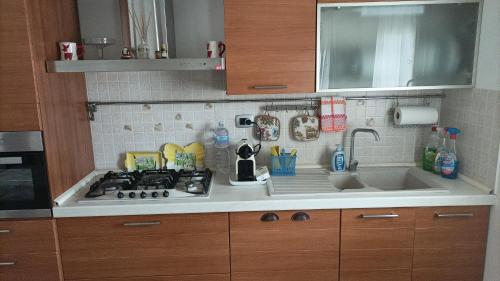 um balcão de cozinha com um fogão e um lavatório em Casa Emily em Fano