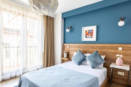 a bedroom with blue walls and a bed with blue pillows at Convenient Flat 10 min to Taksim and Citys Mall in Istanbul