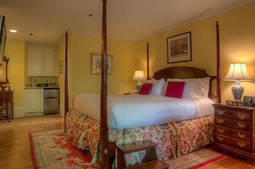 a bedroom with a large bed and a kitchen at Francis Malbone House in Newport