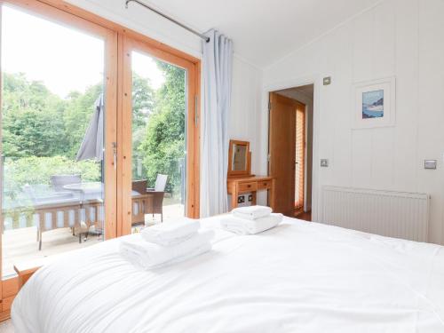 een slaapkamer met een wit bed en een groot raam bij 6 Water's Edge in Looe