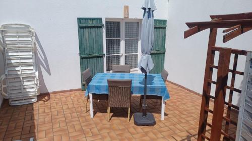 a table with a blue table cloth on a patio at LE clos do ré in Sainte-Marie-de-Ré