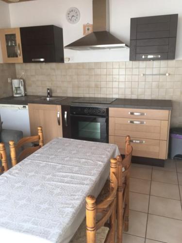 une cuisine avec une table et une cuisinière four supérieur dans l'établissement LE clos do ré, à Sainte-Marie de Ré